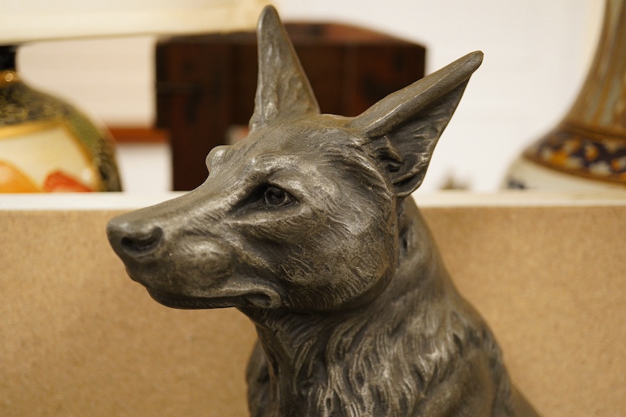 An Art Deco patinated metal Alsatian figure group raised on stepped base, 70cm wide. Condition - good, some chipping to the base